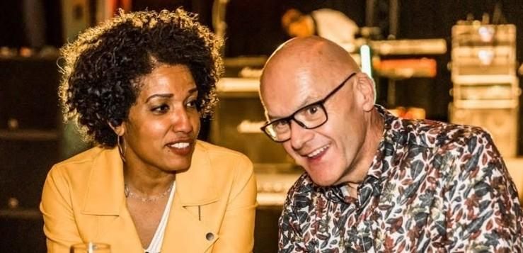 A couple engaged in an animated conversation. They seem to be enjoying a relaxed atmosphere.