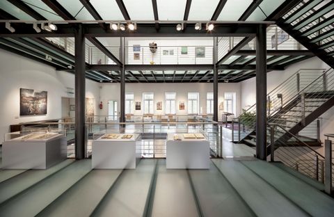 Ein modernes Ausstellungsgebäude mit einer offenen Raumgestaltung. Große Fenster lassen viel Licht herein und schaffen eine einladende Atmosphäre.