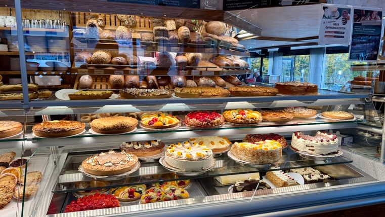 Eine Auswahl an verschiedenen Torten, darunter Erdbeertorte, Biskuit und Sahnetorten. Die Farben und Dekorationen sind einladend und verleihen der Präsentation einen festlichen Eindruck.