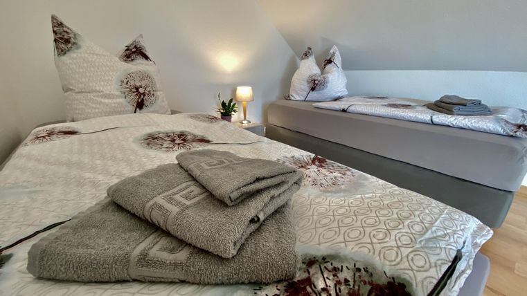 Ein schön dekoriertes Schlafzimmer mit zwei Betten. Saubere Handtücher und eine entspannende Atmosphäre sind vorhanden.