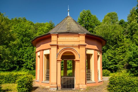 Lindenquelle vor grünen Bäumen