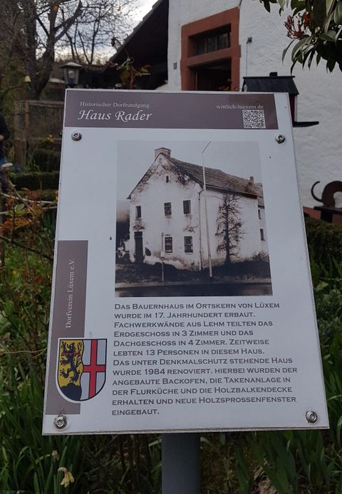 Ein historisches Bauernhaus in LUXEM, erbaut im 17. Jahrhundert. Ein Schild informiert über die Renovierung und die Geschichte des Hauses.