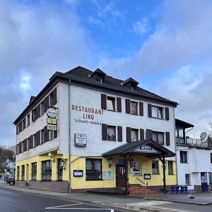 Ein Gebäude mit dem Schriftzug "Restaurant Lind" an der Fassade. Es ist ein mehrstöckiges Haus in einer ruhigen Straßenlage.