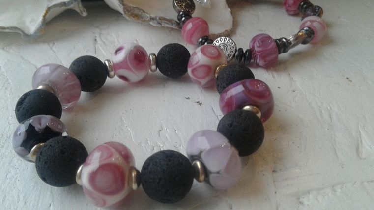 Armband van roze glazen kralen met zwarte kralen.