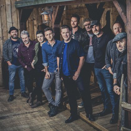 Tien mannen in casual kleding in een kamer met veel hout