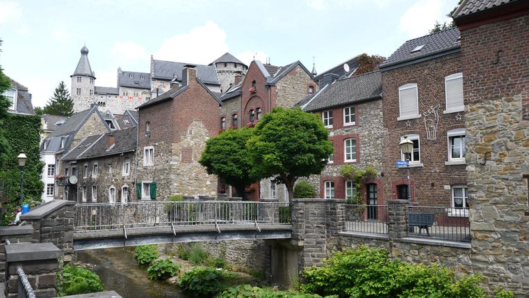 Historische Gebäude und eine Brücke über einen Bach in Stolberg, Deutschland.