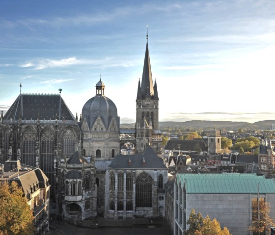 Der Aachener Dom im Sonnenuntergang, umgeben von der Stadtlandschaft. Der Himmel ist klar mit wenigen Wolken., &copy; ats, B. Schroeder