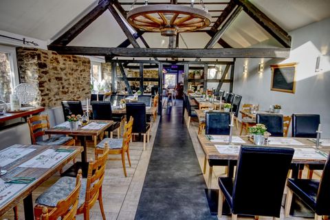 Ein modernes Restaurant mit Holzdekor und großen Fenstern. Die Tische sind elegant gedeckt und es gibt eine gemütliche Atmosphäre.