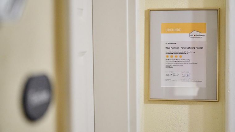 Een ingelijst certificaat hangt aan de muur. Het toont een onderscheiding voor een dienst met meerdere beoordelingssterren.