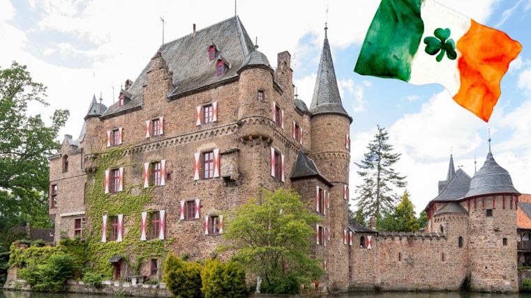 Een pittoresk kasteel met torens en een omliggend groen terrein. Op de voorgrond wappert een Ierse vlag.