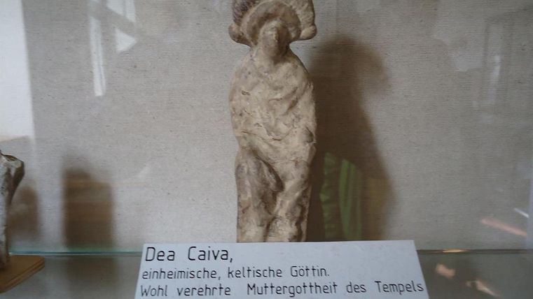 Terrakottafigur der keltischen Göttin Dea Caiva in einer Vitrine. Beschriftung erklärt ihre Bedeutung als Muttergottheit des Tempels am Juddekirchhof.