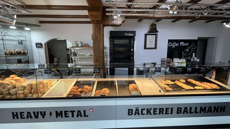 Interior bakery in white with wooden beams, counter with bakery goods