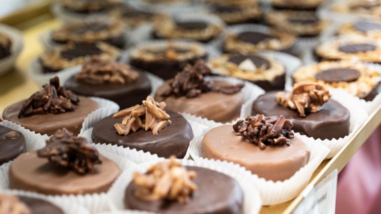 A selection of delicious chocolate cookies in various varieties. Some cookies are garnished with nuts and presented in paper cups.