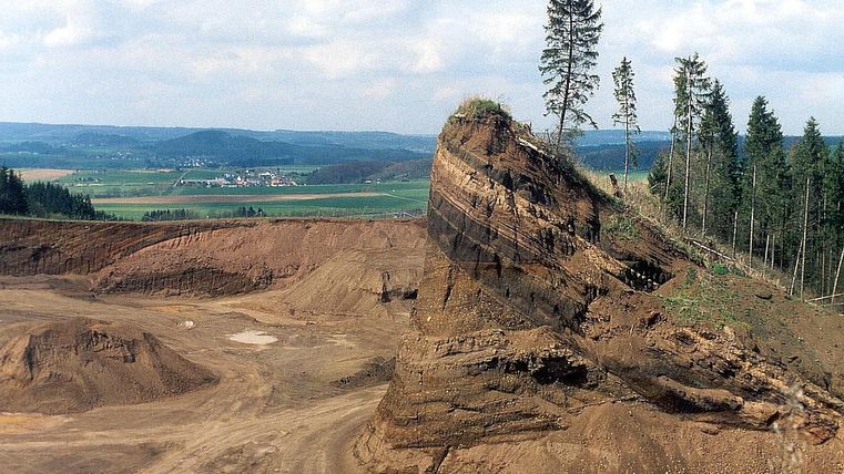 Quarry Rockeskyller Kopf with distinctive rock and trees, surrounded by wide landscape and fields.