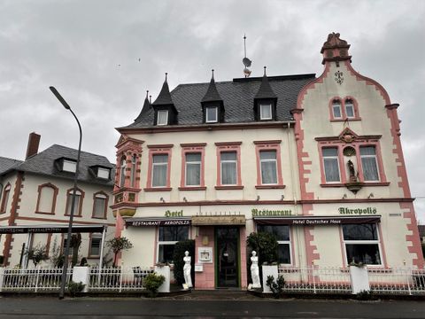 Een historisch gebouw met een opvallende, kleurrijke façade. Het heeft een stijlvol dak en een uitnodigende sfeer.