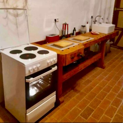 Eine moderne Küche mit einem weißen Herd und einer Holzwerkbank. Auf der Werkbank befinden sich mehrere Schneidebretter und verschiedene Küchenutensilien.