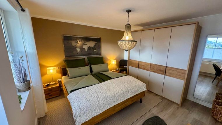 Ein gemütliches Schlafzimmer mit einem Kingsize Bett, einem Kleiderschrank und hochwertigen Matratzen für einen erholenden Schlaf und Entspannung.
