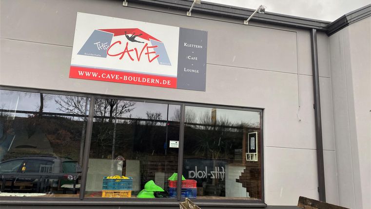 A shop with an inviting facade. The sign displays the name "CAVE" and information about the website.