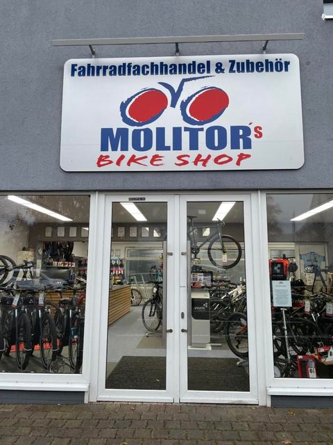 Een fietsenwinkel met de naam "Molitors Bike Shop". Fietsen en accessoires zijn zichtbaar.