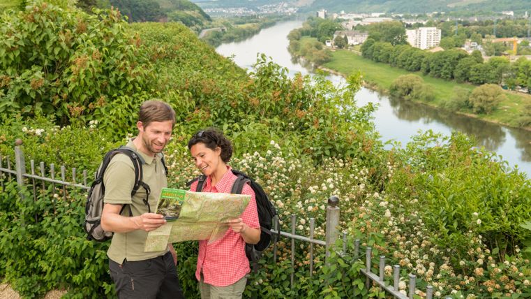 Twee wandelaars kijken op een kaart voor een rivierlandschap.