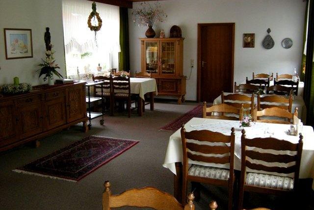 Een gezellig restaurant met houten meubels en een idyllische sfeer. De tafels zijn mooi gedekt en omgeven door een warm licht.