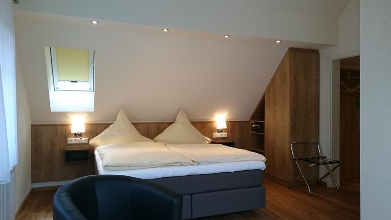 Ein gemütliches Schlafzimmer mit zwei Einzelbetten und modernem Design. Die Wände sind hell, und es gibt ein Fenster, das für natürliches Licht sorgt.