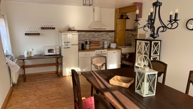 A cozy kitchen with a large dining table and modern appliances. The interior is bright and inviting, ideal for social evenings.