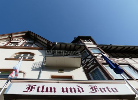 Ein Gebäude mit dem Schild "Film und Foto". Der Himmel ist klar und blau.