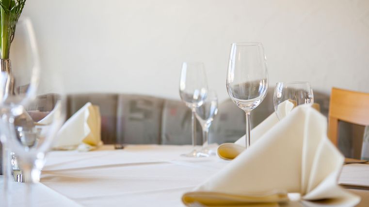 Ein eleganter Tisch, gedeckt mit Gläsern und gefalteten Servietten. Die dezenten Farben schaffen eine einladende Atmosphäre.