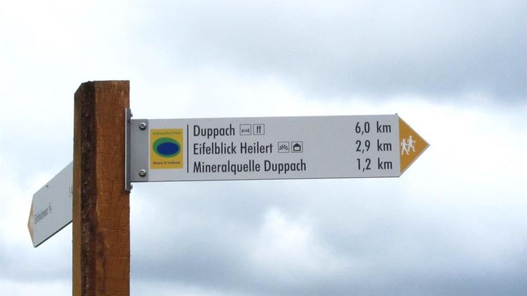 Wegweiser mit Entfernungsangaben zu Duppach, Eifelblick Heilert und Mineralquelle Duppach.