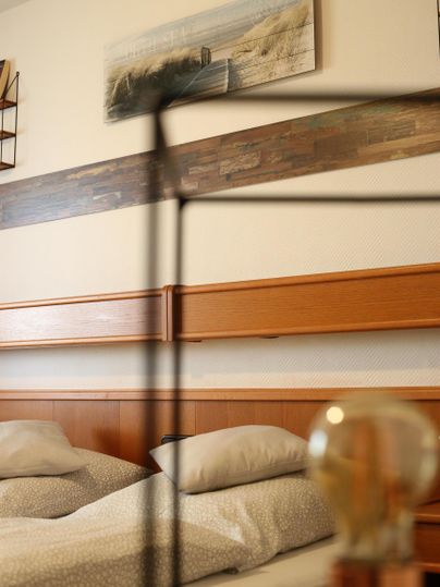 Ein gemütliches Schlafzimmer mit einem Doppelbett und weichen Kissen. An der Wand hängt ein schönes Gemälde.