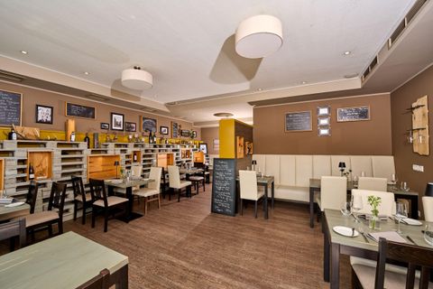 Een modern restaurant met houten meubels en een gezellige sfeer. De muren zijn versierd met foto's en borden.