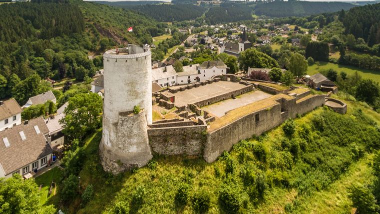 Luftaufnahme der Burg Reifferscheid mit umliegender Landschaft.