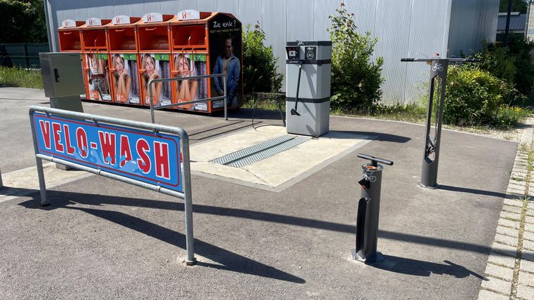 Een fietswasplaats met meerdere wasstations voor fietsen. Op de achtergrond zijn schoonmaakfaciliteiten beschikbaar.