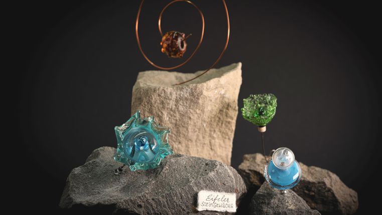 Unikaten van glas in lichtblauw, groen en roodbruin, die Eifeler steenplanten voorstellen.