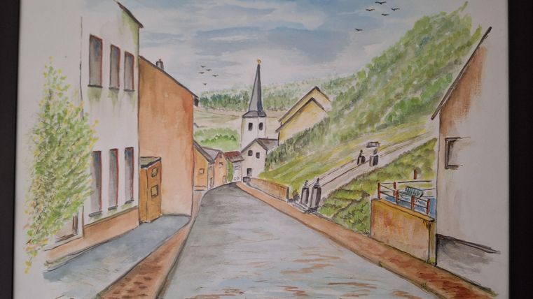 Eine malerische Straße in einem kleinen Dorf, umgeben von sanften Hügeln. Im Hintergrund steht eine Kirche mit einem hohen Turm.