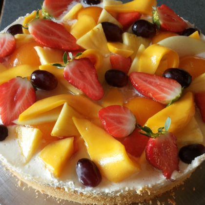 Een heerlijke fruitschaal met verse vruchten zoals mango's, aardbeien en druiven. De kleurrijke versiering maakt het bijzonder aantrekkelijk.