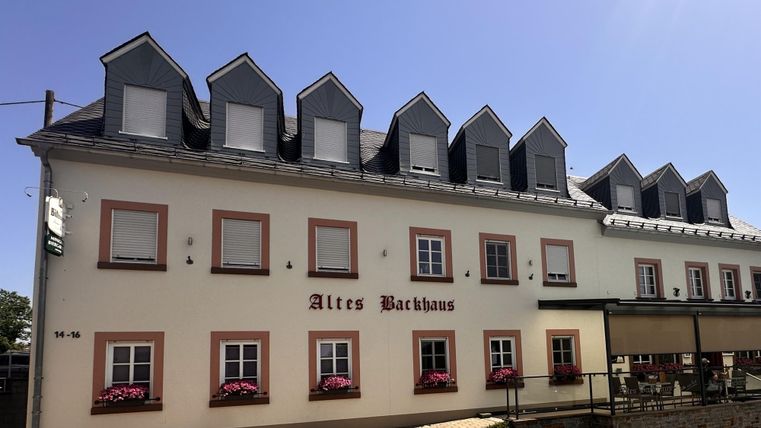 Ein historisches Gebäude mit dem Namen "Altes Bräuhaus". Es hat mehrere Fenster und ein einladendes Ambiente.