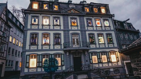 Ein historisches Gebäude mit bunten Fenstern und einer schönen Fassade. Der Abendhimmel ist grau und verleiht der Szene eine ruhige Atmosphäre.