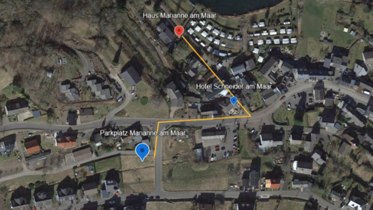 Eine Kartenansicht eines kleinen Dorfes mit markierten Punkten. Die Orte umfassen "Haus Maranne am Maar", "Hotel Schneider am Maar" und einen Parkplatz.