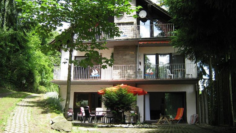 Ein gemütliches Haus im Grünen mit einem Garten und einer Terrasse. Die Umgebung ist grün und einladend, ideal zum Entspannen.