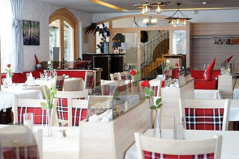 Ein elegantes Restaurant mit weißen Tischtüchern und roten Akzenten. Die Einrichtung ist modern und einladend, ideal für ein angenehmes Essen.