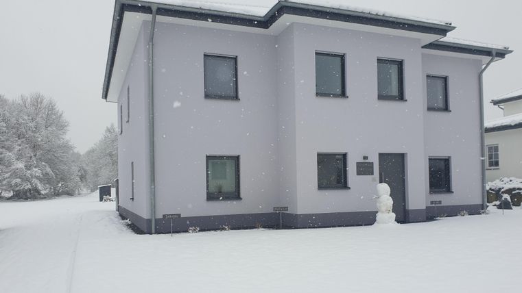 Ein modernes Haus in einer verschneiten Landschaft. Die Winterlandschaft ist ruhig und friedlich.
