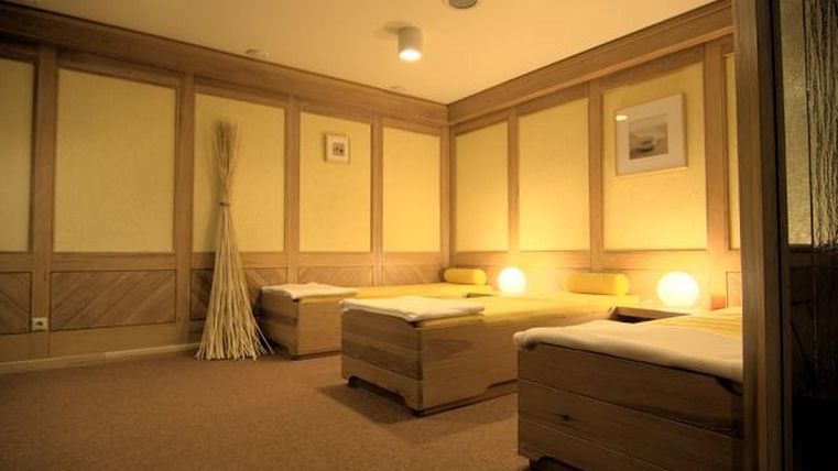 Een rustige ruimte met houten meubels en zachte verlichting. De sfeer is ontspannend en aangenaam, ideaal voor wellness en ontspanning.