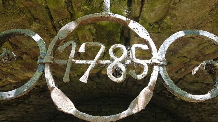 Eine eiserne Ornamente mit der Jahreszahl 1785. Das Bild zeigt einen rustikalen, historischen Stil.