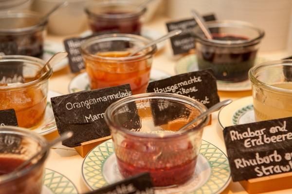 Een selectie van verschillende jam in kleine potjes. Elk potje is voorzien van een label met de smaak.