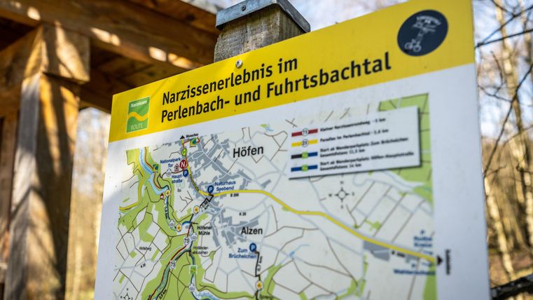 Een wegwijzer met een kaart van de Narcisse-ervaring in het Perlenbach- en Fuhrtbachtal. De kaart toont verschillende paden en locaties in de omgeving.