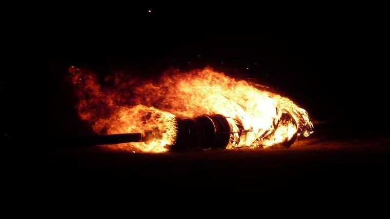 Een brandend voorwerp straalt fel in het donker. Vlammen omringen het object en zorgen voor een dramatische scène.