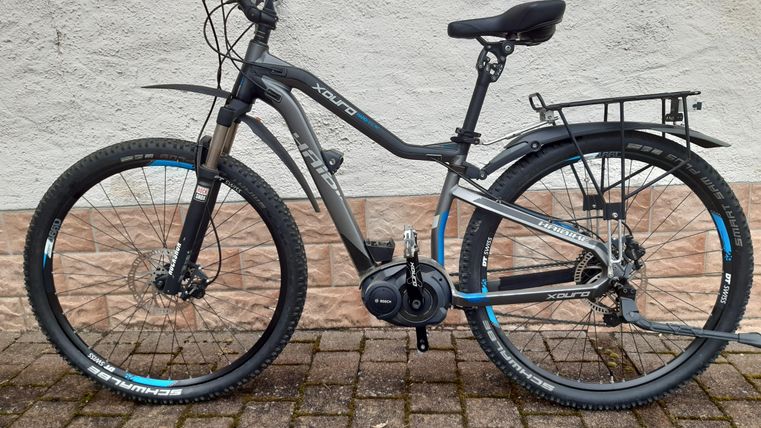 Ein modernes Fahrrad mit einem stabilen Rahmen und dickeren Reifen. Es hat einen Gepäckträger und eine eckige Form, ideal für verschiedene Terrains.