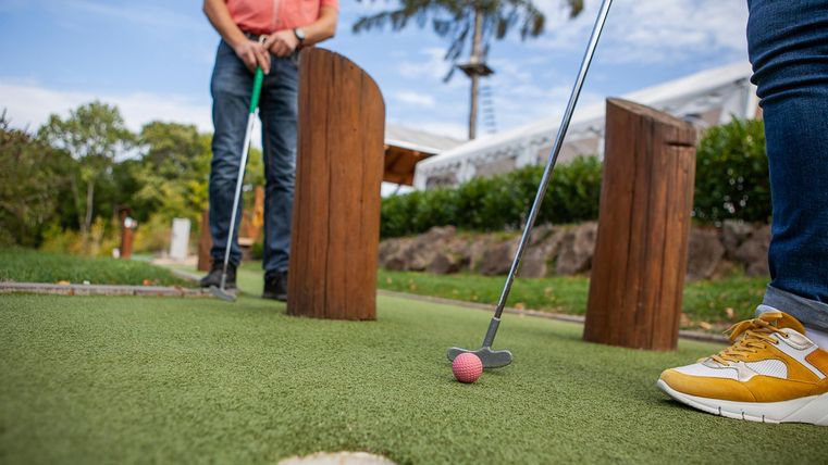 two people playing miniature golf